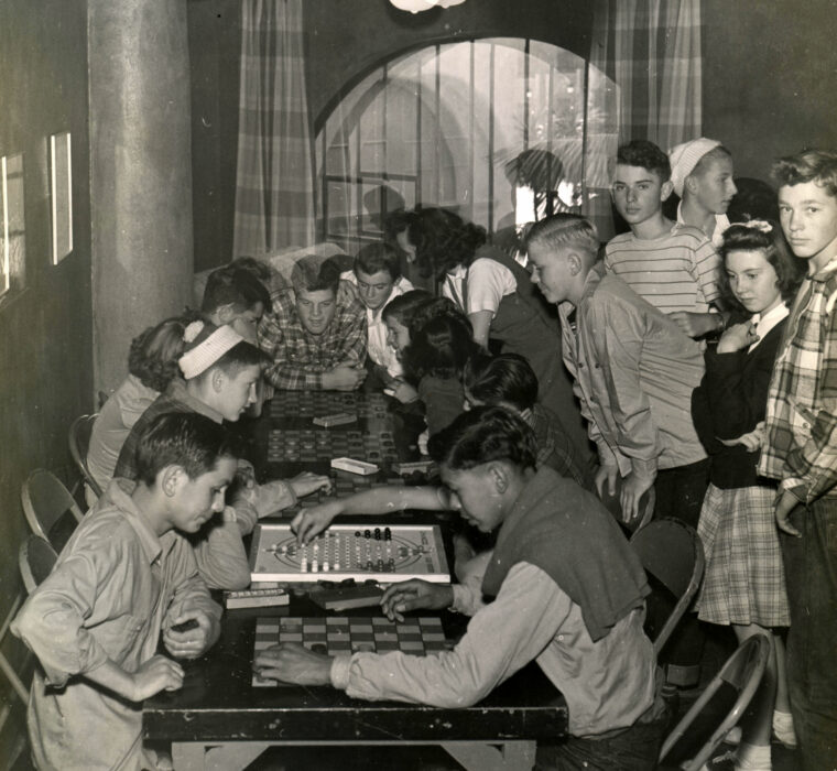 Youth playing chess in the game room, 1940s