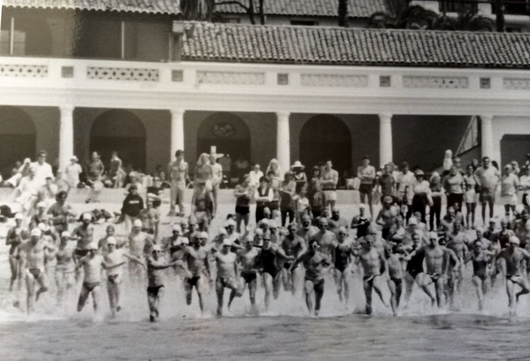 Cabrillo Pavilion from the water, people running into the ocean